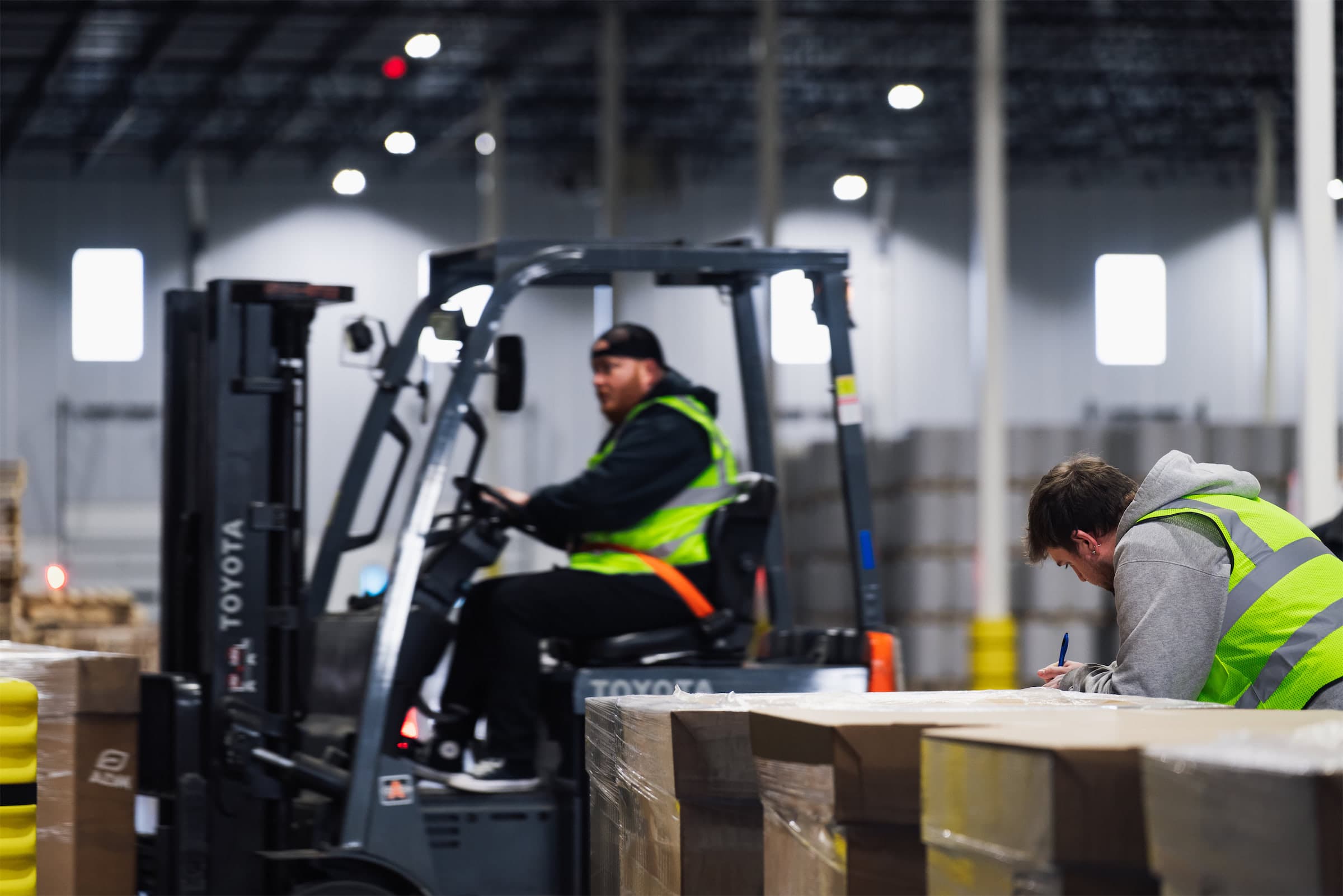 Forklift operator and logistics coordinator on the warehouse floor